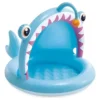 Visão frontal do guarda-sol em formato de peixe das piscinas baby fisch 45 litros intex 58419 infladas no jardim.